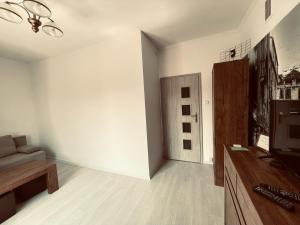 a living room with a couch and a television at EASY RENT- Lublin Chopina CityCentre Free Parking 24h Check-in in Lublin