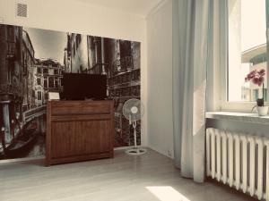 a living room with a tv on a wooden dresser at EASY RENT- Lublin Chopina CityCentre Free Parking 24h Check-in in Lublin