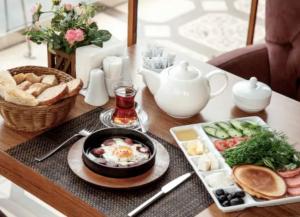 een ontbijttafel met een kom eieren en een bord eten bij PANORAMA HOTEL in Tyachiv
