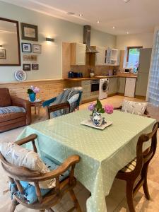 cocina y sala de estar con mesa y sillas en Portelet Bay, en St Brelade