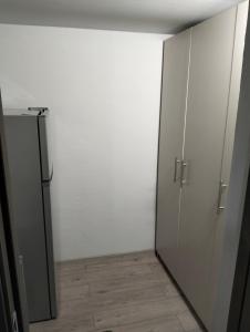 an empty room with a white wall and a refrigerator at Kub A - 15min de Toplita in Sărmaş