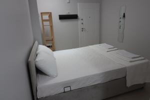 a white bed with white sheets and pillows on it at power suit in Fethiye