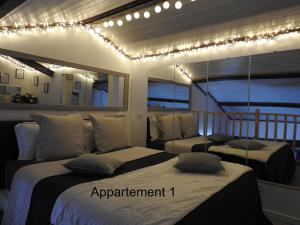 - 2 lits dans une chambre avec des lumières sur le mur dans l'établissement Love Room Narbonne, à Narbonne