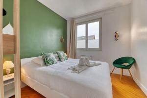 a bedroom with a white bed and a green wall at Saint Maur * F2* beau logement entier in Rouen