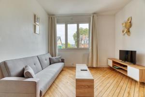 a living room with a couch and a tv at Saint Maur * F2* beau logement entier in Rouen