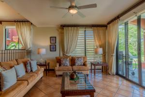a living room with a couch and a ceiling fan at Bougainvillea 5102 Luxury Apartment - Reserva Conchal in Playa Conchal
