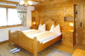 een slaapkamer met een groot bed in een houten kamer bij Apart Resort Rabl in Westendorf