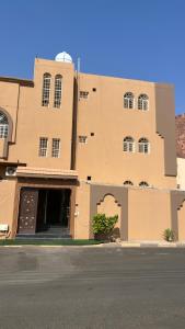 a brown building with a street in front of it at لانا العلا شقق مفروشة Lana Alula in Al-ʿUla