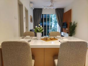 una cocina con una mesa con sillas y un jarrón de flores en Perfect Rating Nexflix Jaya One Mall Seksyen 13 PJ en Petaling Jaya