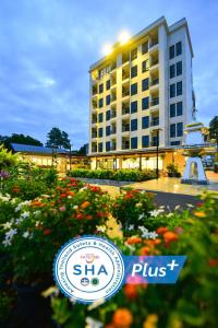 a hotel sign in front of a building with flowers at NORN Rimkhlong Bangkok นอนริมคลอง in Bangkok Noi