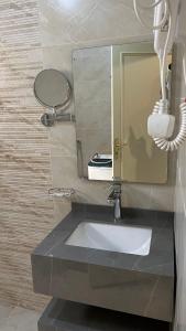 a bathroom with a sink and a mirror at لانا العلا شقق مفروشة Lana Alula in Al-ʿUla