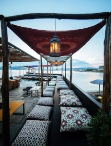 a row of cushioned benches on a pier with the ocean at F2 Central Luxury Apartment in Volos