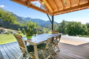 a wooden table and chairs on a deck with mountains at Le Septentrion chambre d'hôtes 2-4 personnes in Revel