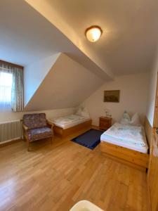 a attic room with two beds and a chair at Unterfuchs in Schladming