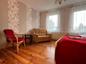a bedroom with a bed and a chair and a couch at Ferienwohnung Landlust - ideal für Hundefreunde und Monteure, free WLAN & Parken, Smart-TV in Uebigau