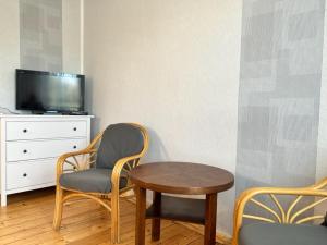 a room with a table and chairs and a tv at Ferienwohnung Landlust - ideal für Hundefreunde und Monteure, free WLAN & Parken, Smart-TV in Uebigau