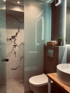 a bathroom with a toilet and a sink at Rainbow Suites Thessaloniki in Thessaloniki
