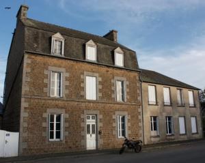 a brick building with a motorcycle parked in front of it at The Old School House in Céaucé