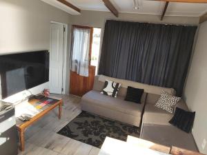 a living room with a couch and a tv at Paradise Lake flats in Sedgefield