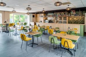 un ristorante con tavoli in legno e sedie gialle di Hoeve de Bongerd a Beesel