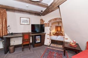 ein Wohnzimmer mit einem Kamin und einem Bett in der Unterkunft Schlosshotel Neufahrn in Neufahrn in Niederbayern