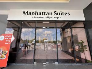DonggongonにあるITCC Manhattan Suites by Stay In 3paxの看板を持って店の前を歩く女