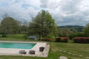 にあるAppartement au sud de la Creuse avec piscineのラウンジチェア2脚付きの庭のスイミングプールを利用できます。