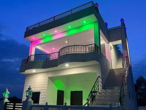 uma casa grande com luzes acesas à noite em Govardhan villas Guest House & Farm Stay em Bijāpur