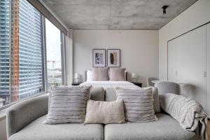 a bedroom with a bed and a couch with pillows at South Lake Union studio w gym storage nr parks SEA-558 in Seattle +26 photos