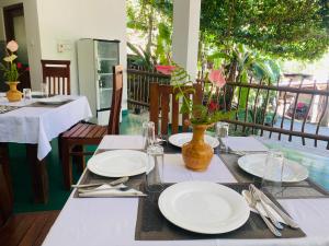 a table with white plates and a vase on it at Misty Elegance - Ella. in Ella