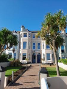 a large white building with palm trees in front of it at Astala Lodge in Bangor