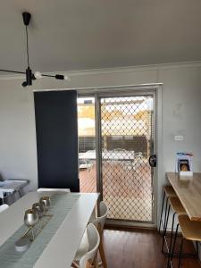 a kitchen with a table and chairs and a balcony at House on Ryan in Broken Hill