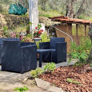 eine Terrasse mit 2 Stühlen und einem Tisch mit Blumen in der Unterkunft Casa da Maria, Montegrazie (IM) in Montegrazie