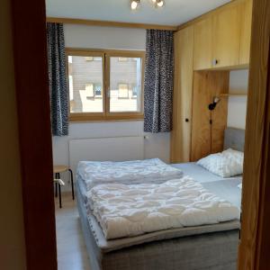 um quarto com uma cama e uma janela em Gentianes COSY & MOUNTAIN apartments em Veysonnaz