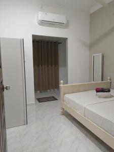 a bedroom with a bed and a air conditioner at Inara Homestay Besut in Jertih