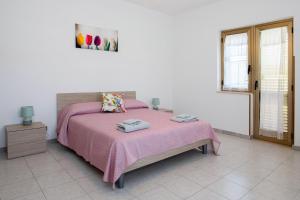 um quarto com uma cama com um cobertor rosa em Zion Mare em Soverato Superiore
