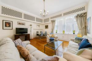 a living room with a couch and a tv at HydePark Queens Gate Apt in London
