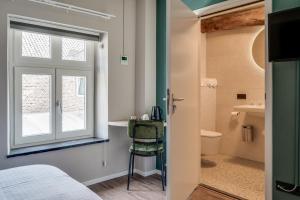een kamer met een bed, een raam en een badkamer bij Hoeve de Bongerd in Beesel