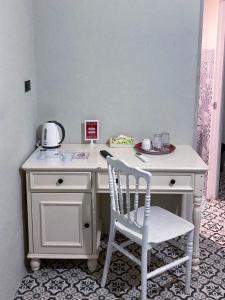 - Escritorio blanco con silla en la habitación en 2499 Heritage Chinatown Bangkok Hotel By RoomQuest en Pom Prap