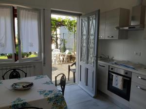 une cuisine avec une table et une porte donnant sur une terrasse. dans l'établissement Casa fontana rossa, à Arizzano