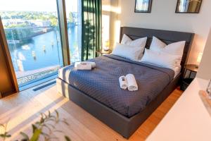 1 dormitorio con 1 cama con 2 zapatillas en CABANA - TheView - 10th Floor - Terrasse - Waterfront - Hafenviertel, en Oldenburg