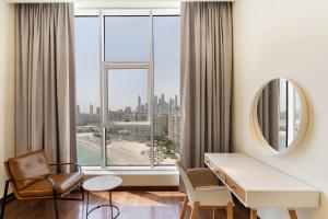 a hotel room with a desk and chair and a mirror at Tanzanite Residence Palm Jumeirah- 2BR & Maids Room - Allsopp&Alsopp in Dubai