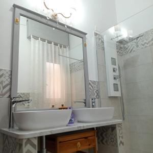 a bathroom with a white sink and a mirror at Centro Storico Carloforte in Carloforte