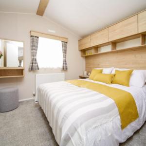 a bedroom with a large bed with yellow pillows at Edwards Holiday Home in Blackpool