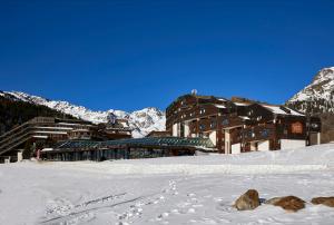 a ski lodge in the snow in front of a mountain at Blu Hotel Senales Zirm-Cristal in Maso Corto