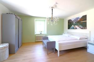 a bedroom with a white bed and a chandelier at Montfort Apartments - Feldkirch in Feldkirch