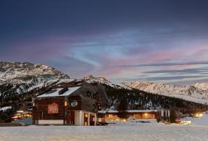 ein Gebäude im Schnee vor einem Berg in der Unterkunft Blu Hotel Senales Zirm-Cristal in Kurzras