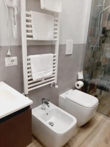 Baño blanco con lavabo y aseo en Novalis Rooms, en Porto Cesareo