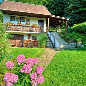 Casa con balcón con flores rosas en el patio en Dobra Chata V Dobre en Frýdek-Místek