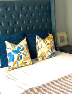 a bed with a blue headboard and two pillows at The Oasis in Hartbeespoort